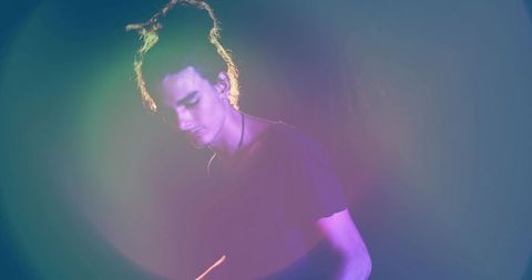 Male performer in vibrant multicolored spotlight