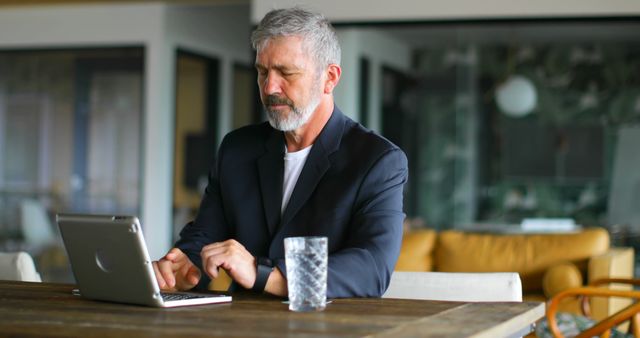 Older businessman focused on working with laptop in modern office - Download Free Stock Images Pikwizard.com