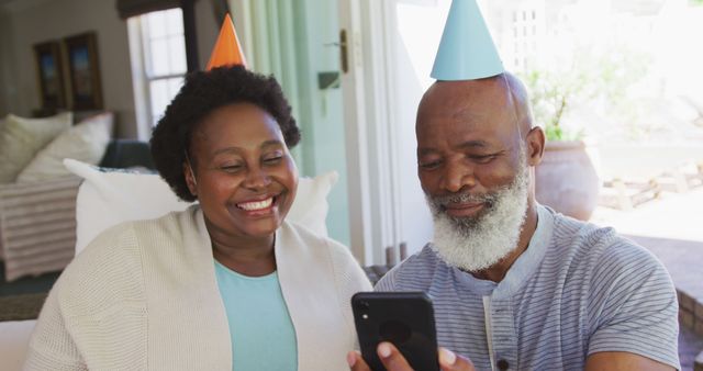 Senior Couple in Party Hats Enjoying Birthday Video Call at Home - Download Free Stock Images Pikwizard.com