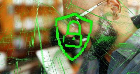 Senior colleagues analyzing cybersecurity dashboard with green pixelated shield overlay