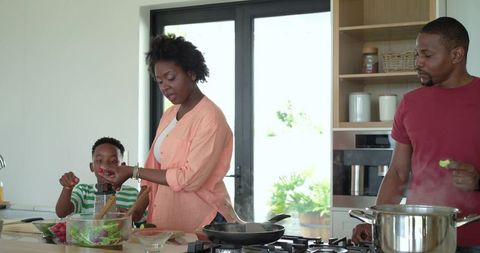 African American Family Preparing Healthy Meal Together at Modern Kitchen Island