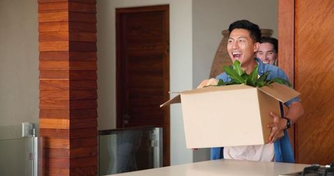 Happy Gay Couple Unpacking Boxes in New Home Journey