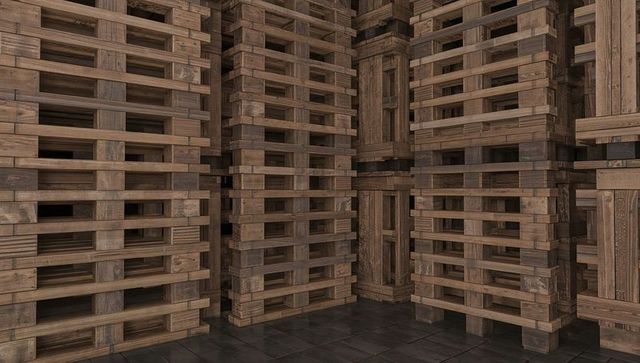 Stacking wooden pallets forming dense warehouse aisles with timber grain and shadows