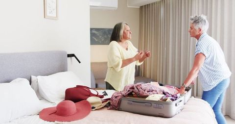 Senior Couple Packing Suitcase for Exciting Vacation Plan