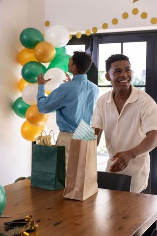 Diverse Friends Decorating with Green and Gold Balloons