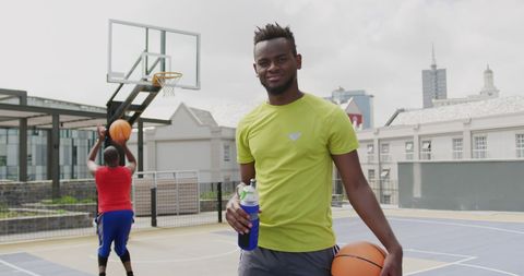 Confident Basketball Player Holding Ball on Outdoor Court