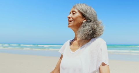 Senior Woman Enjoying Serenity on Sunny Beach - Download Free Stock Images Pikwizard.com