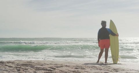 Senior Woman Holding Surfboard at Beachfront for Active Lifestyle - Download Free Stock Images Pikwizard.com