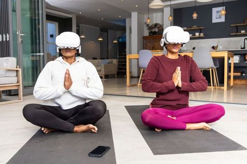 Diverse women practicing vr meditation and yoga at home, mindfulness, wellness tech, lifestyle