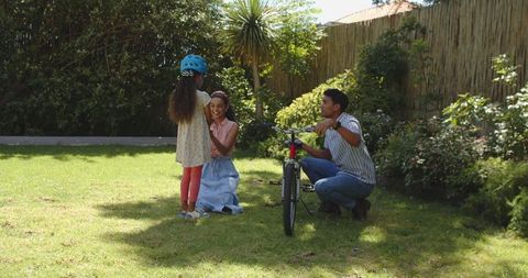 Parents teaching child to ride bike outdoors