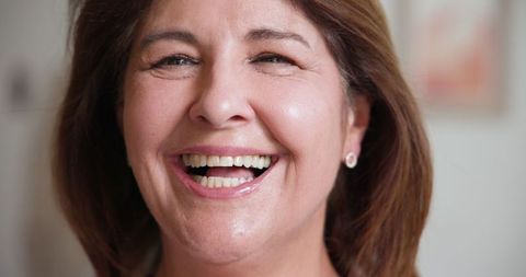 Senior woman smiling with joy and sophistication in studio portrait