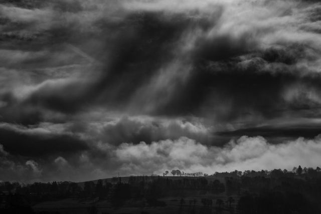Moody Landscape with Dramatic Clouds Over Hills - Download Free Stock Photos Pikwizard.com