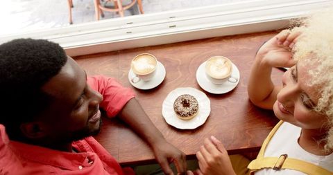 Happy Couple Enjoying Coffee and Pastry in Cozy Cafe Setting