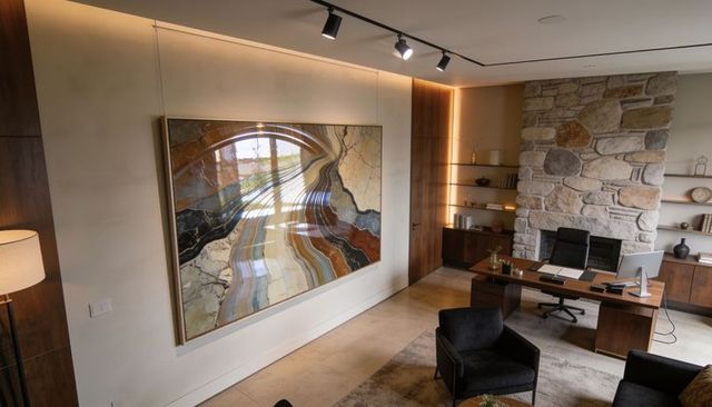 Contemporary home study featuring large abstract framed artwork and stone fireplace