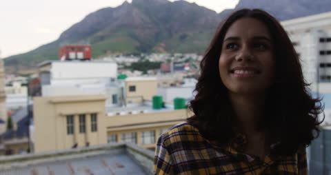 Smiling Woman Enjoying Rooftop Party with Scenic Cityscape