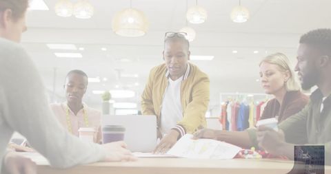 Creative fashion designers collaborating over sketches in studio