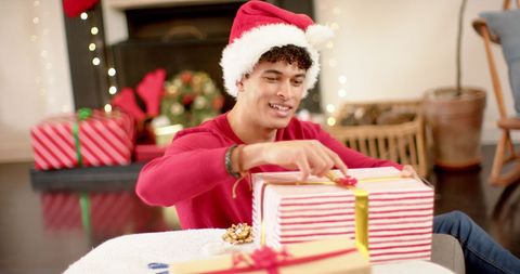 Young Man Wrapping Christmas Gifts at Home - Download Free Stock Images Pikwizard.com