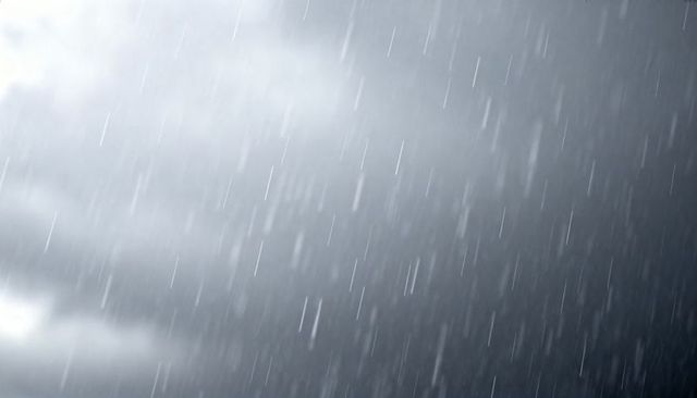 Heavy rain falling in diagonal streaks over dark storm sky dramatic weather background