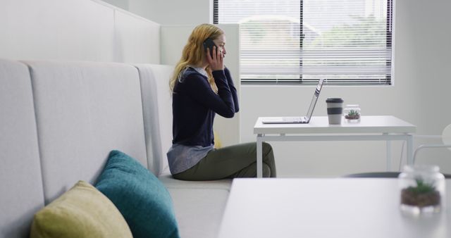 Businesswoman Working in Modern Office on Laptop while Talking on Cellphone - Download Free Stock Images Pikwizard.com