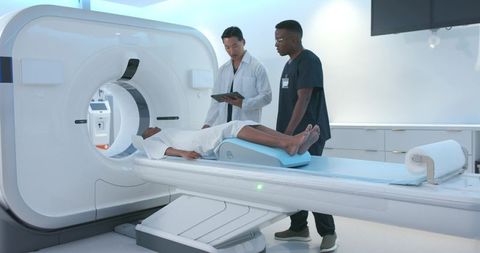 Medical team preparing african american woman for ct scan in modern radiology room