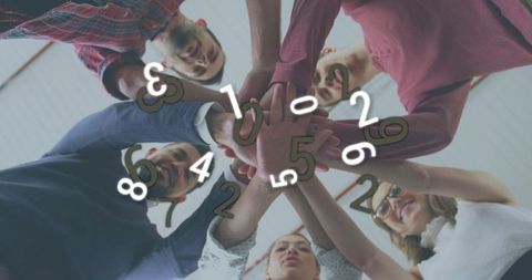 Team stacking hands in huddle under office ceiling with floating numbers representing data