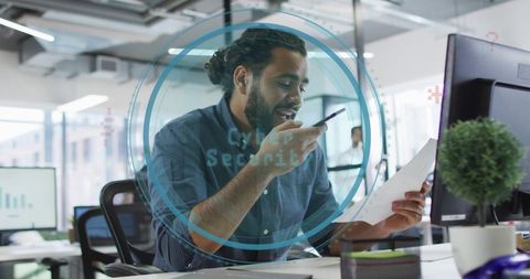 It analyst speaking on phone with cybersecurity overlay in modern open office