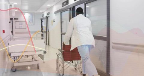 Medical staff pushing wheelchair down hospital corridor with gurney and clinical data waveform overl