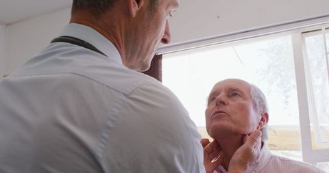 Senior Male Patient Undergoing Check-up by Male Doctor at Retirement Home