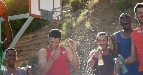 Basketball players celebrating with water splash outdoors