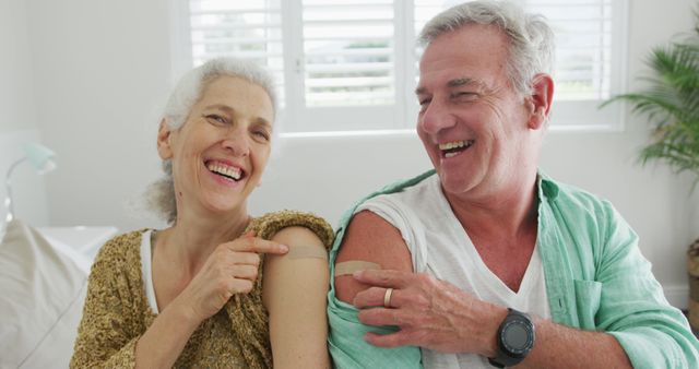 Happy caucasian senior couple showing plasters after vaccination. senior health and lifestyle during covid 19 pandemic.