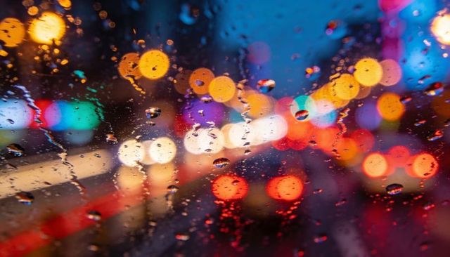 Rain-Soaked Glass with Colorful City Bokeh Lights Driving Night Traffic Reflections Urban