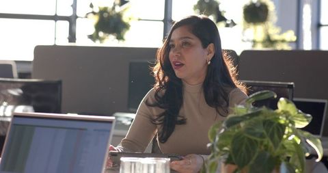 Leading Team Discussion in Modern Office with Tablet and Laptop