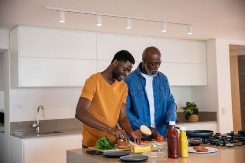 Father and Son Bonding Over Sandwich Preparation in Modern Kitchen