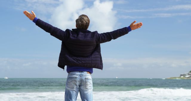 A middle-aged Caucasian man stands with his arms outstretched facing the ocean, with copy space - Download Free Stock Photos Pikwizard.com