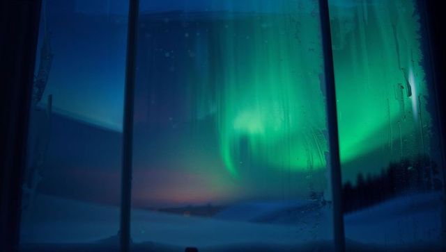 Captivating aurora borealis view through frosty cabin window