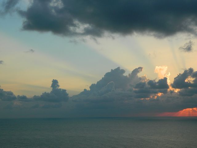 Breathtaking Ocean Sunset with Dramatic Clouds and Sun Rays - Download Free Stock Photos Pikwizard.com
