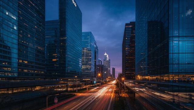 Dusk vehicle light trails on multi-lane urban expressway between glass skyscrapers skyline
