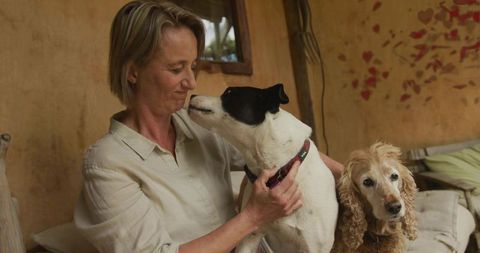 Woman enjoying time with dogs on cozy porch