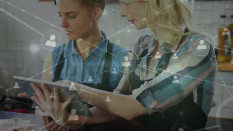 Two Women Collaborating on Digital Tablet with Network Overlay