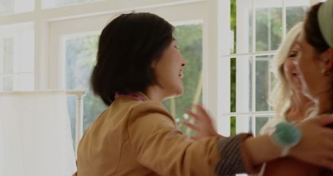 Smiling Bride and Friends Choosing Wedding Dress in Bridal Shop