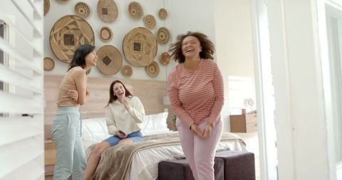 Diverse Women Laughing Together in Modern Bedroom