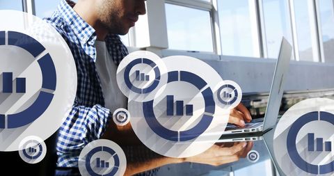 Businessman analyzing data on laptop with overlay of graph icons