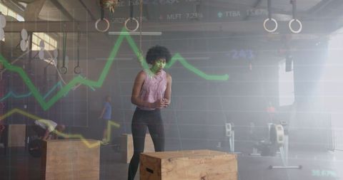 Woman training in gym with digital stock graph overlay