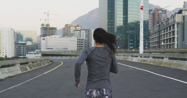 Female runner exercising on urban rooftop at sunrise - Download Free Stock Images Pikwizard.com