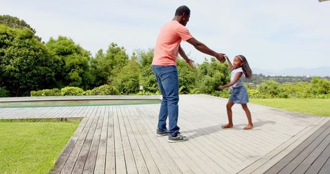 Father-Daughter Bonding on Wooden Deck by Pool