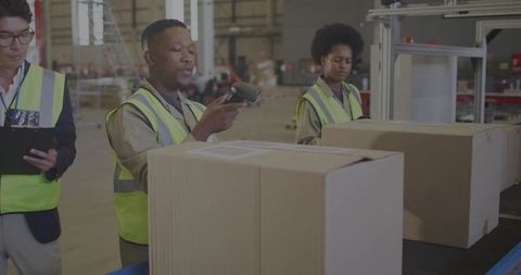 Logistics Team Scanning Packages in Warehouse Environment