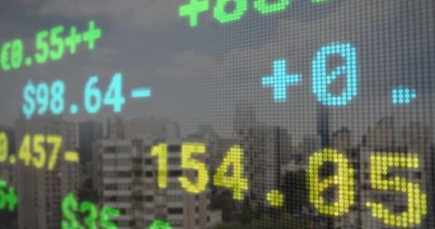 Dot-matrix LED stock ticker updating market prices over hazy urban skyline