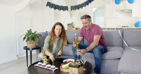 Mature Couple Celebrating Birthday at Home with Treats