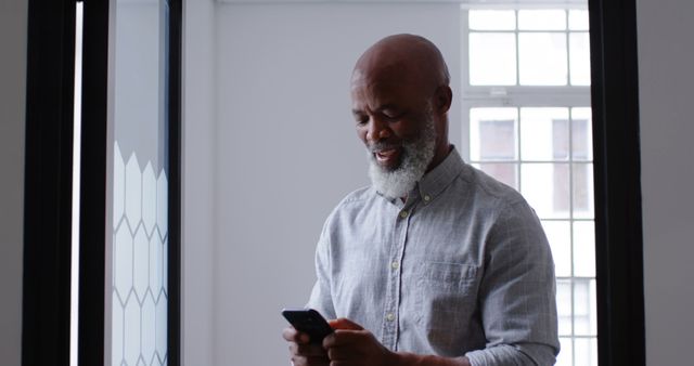 Senior African Man Happy Using Smartphone in Modern Home - Download Free Stock Images Pikwizard.com