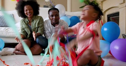 Family Celebrating at Home with Birthday Streamers and Balloons